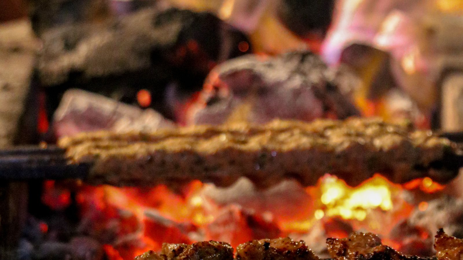 Hardwood charcoal burning down in the pit